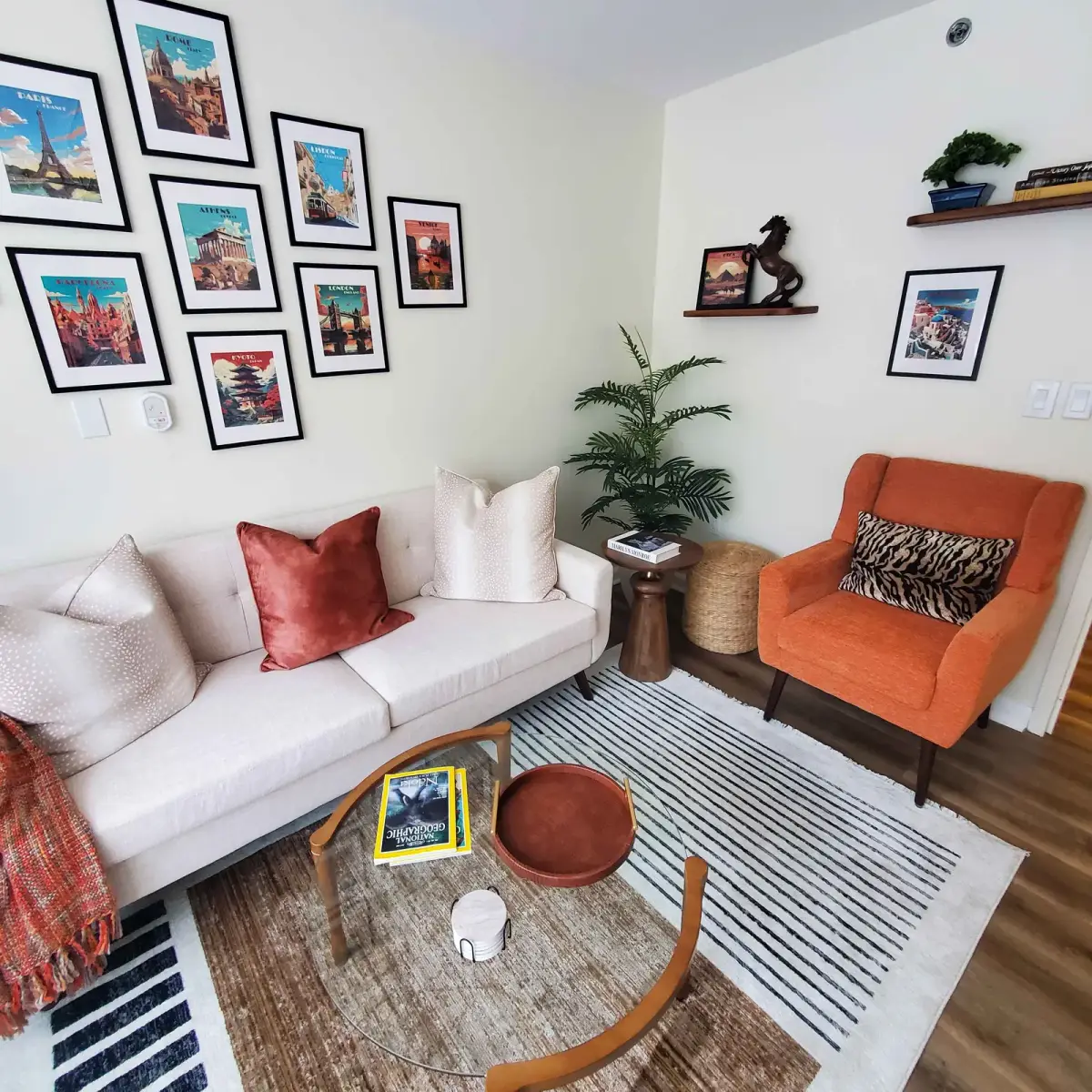 Full view of curated living room with travel poster gallery wall and layered textures — designed by Renata Glaz