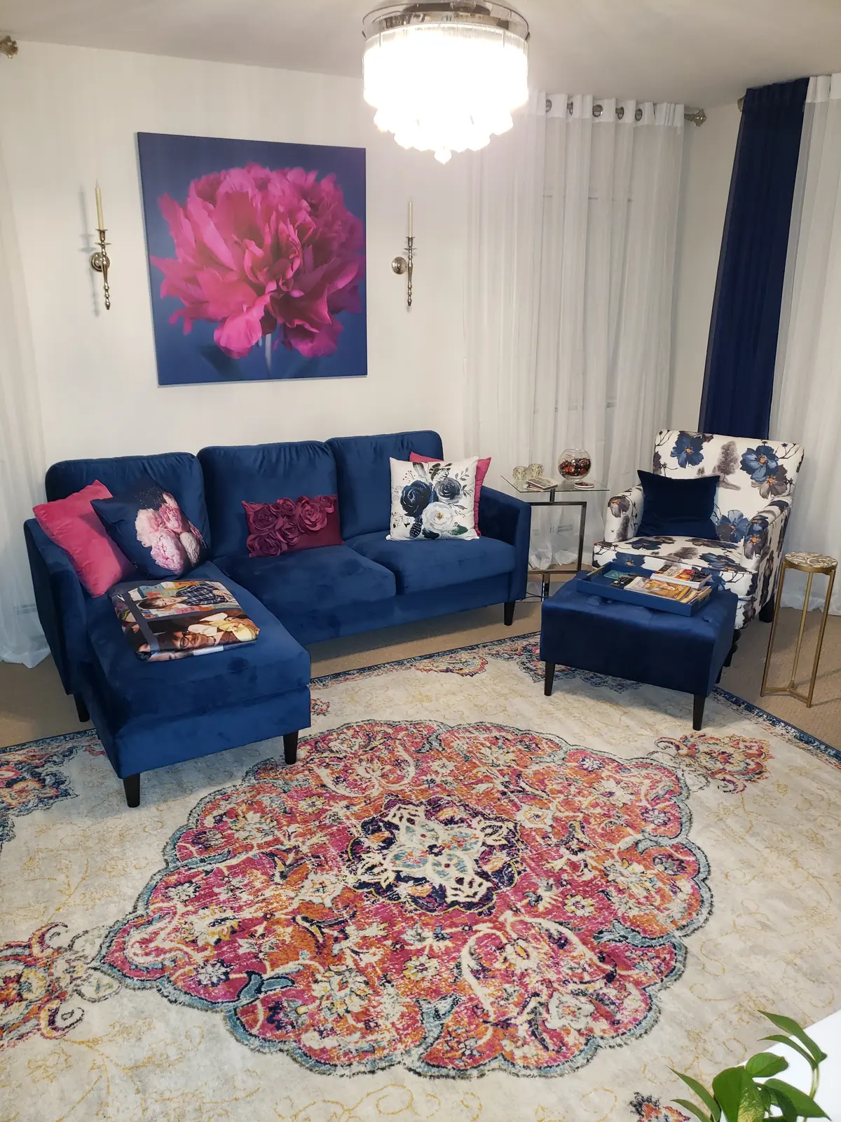 Vibrant living room with navy velvet sofa, pink peony canvas, and floral chair — designed by Renata Glaz