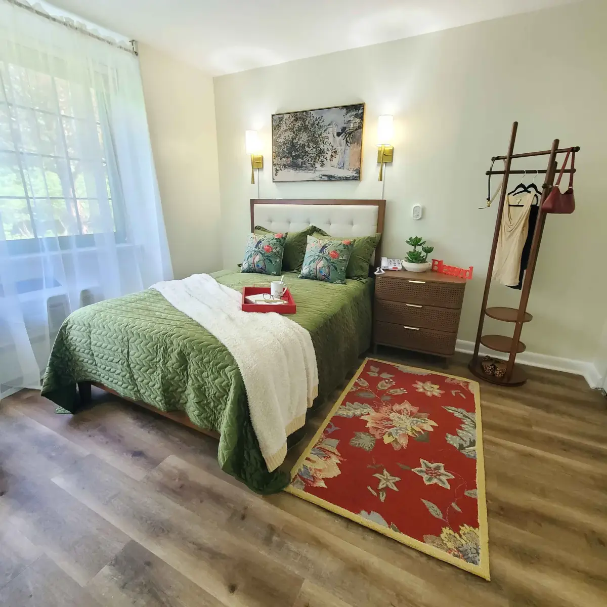 Bedroom styled by Renata Glaz — green quilted bedding, tropical accents, brass sconces