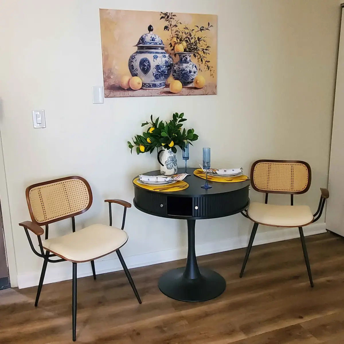 Dining nook designed by Renata Glaz — chinoiserie dishes, yellow tulips, cane-back chairs